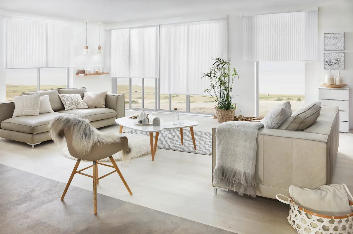 Helles Wohnzimmer mit grossen Fenstern und dezenten weissen Rollo Anlagen als stilvoller Sonnen und Sichtschutz