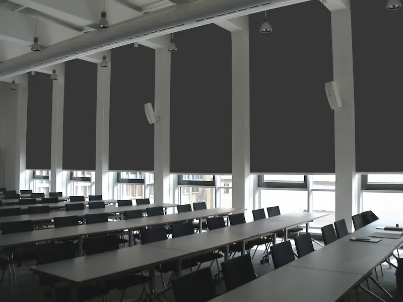 Raum mit moderner Verdunkelungsanlage und vollständig abgedunkelten Fenstern für konzentriertes Arbeiten